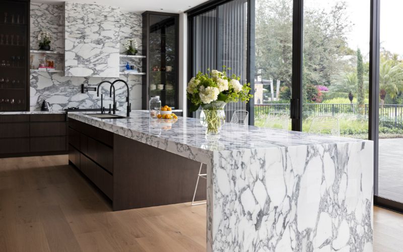 Kitchen countertop and backsplash with white and gray veining.